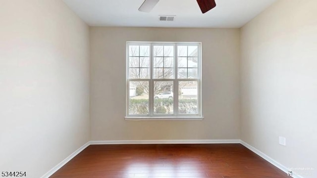 empty room featuring baseboards, wood-type flooring, plenty of natural light, and a ceiling fan