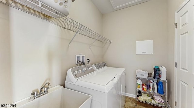 washroom with laundry area, washing machine and dryer, baseboards, and a sink