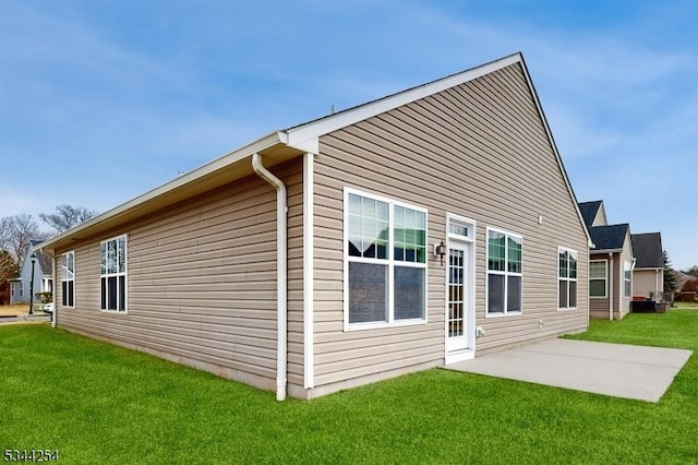 rear view of property with a patio and a lawn