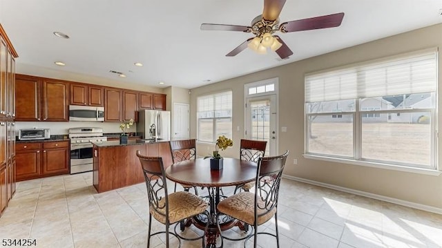 dining area featuring light tile patterned floors, a ceiling fan, baseboards, a toaster, and recessed lighting