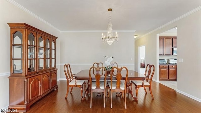 dining space with dark wood-style floors, a notable chandelier, baseboards, and ornamental molding