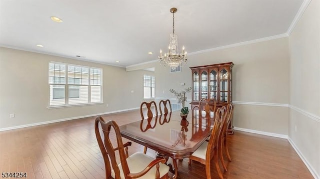 dining space featuring baseboards, an inviting chandelier, and wood finished floors