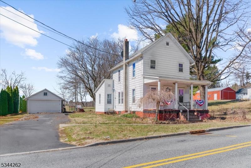 378 Old Main St, Franklin Twp, NJ 08802 - view of front of house featuring a porch, a detached garage, an outdoor structure, and a chimney