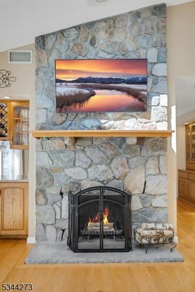 interior details with a fireplace, visible vents, and wood finished floors
