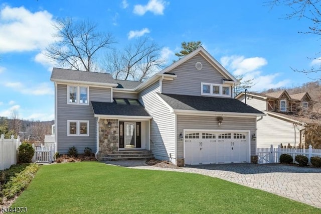 view of front of home featuring a front lawn, fence, a garage, and decorative driveway