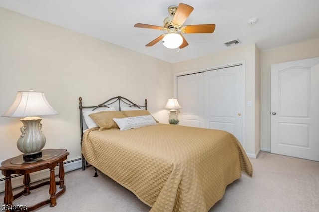 bedroom with a closet, light colored carpet, a ceiling fan, visible vents, and baseboard heating