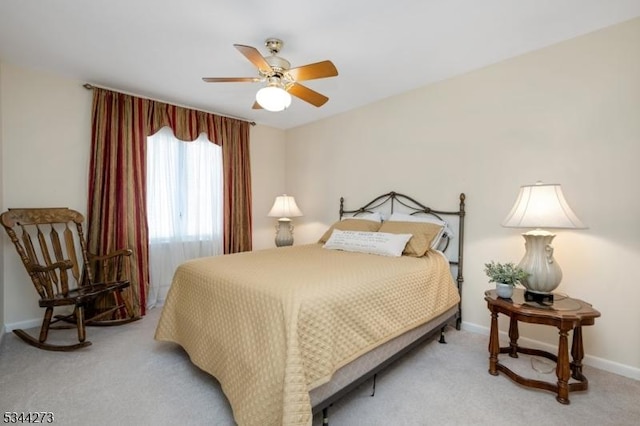 bedroom with baseboards, ceiling fan, and light carpet