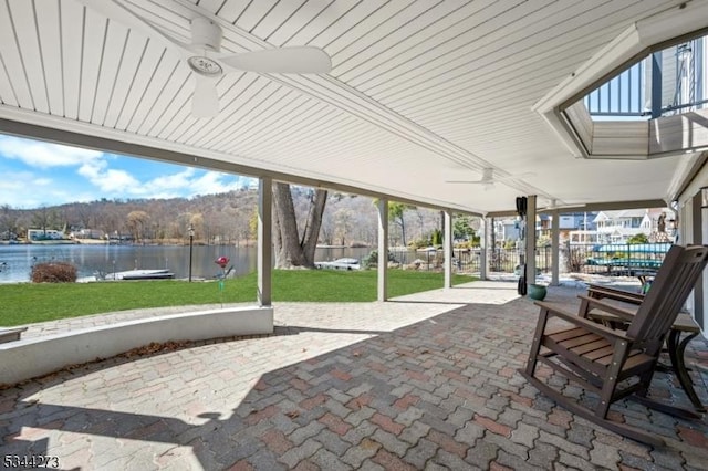 unfurnished sunroom featuring a ceiling fan and a water view