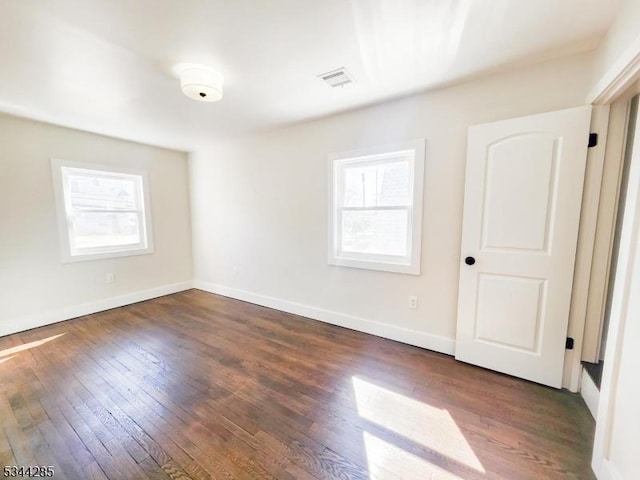 unfurnished room with baseboards, a healthy amount of sunlight, and hardwood / wood-style floors