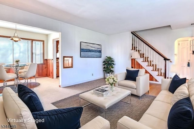 carpeted living area featuring stairs