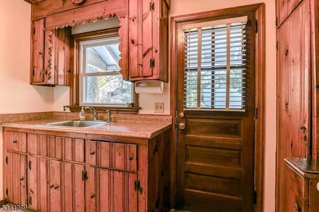 kitchen featuring brown cabinetry, a wealth of natural light, and a sink