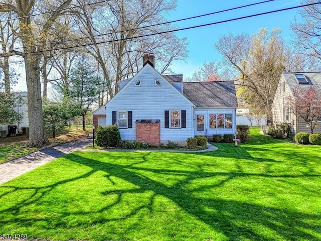 view of front of home featuring a chimney and a front lawn