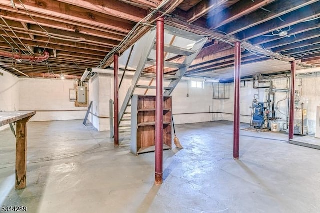 below grade area featuring stairway, electric panel, and a heating unit