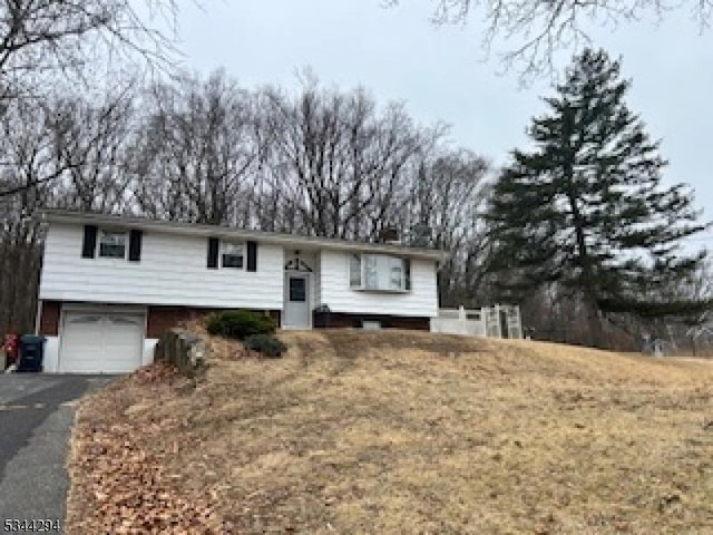 split foyer home featuring aphalt driveway and a garage