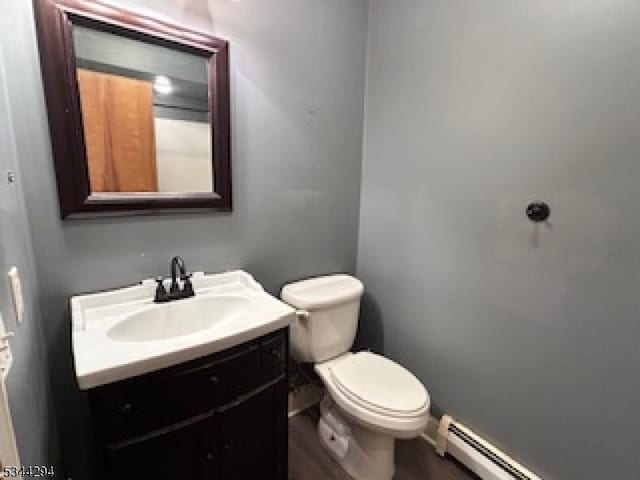 bathroom with vanity, toilet, and a baseboard radiator