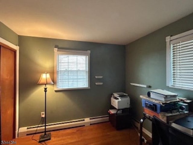 home office featuring baseboards, baseboard heating, and wood finished floors