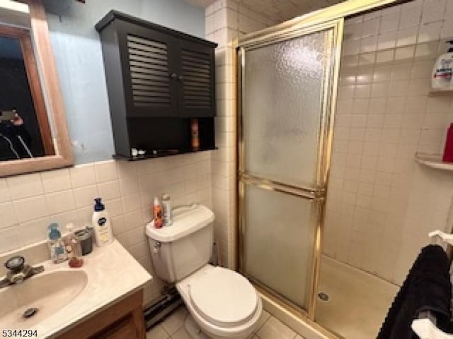 full bathroom featuring vanity, tile walls, toilet, and a stall shower