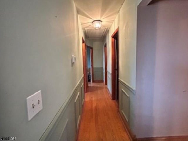 hall with attic access and light wood-style floors