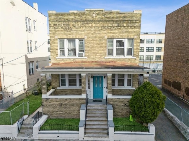 view of front facade featuring fence and brick siding