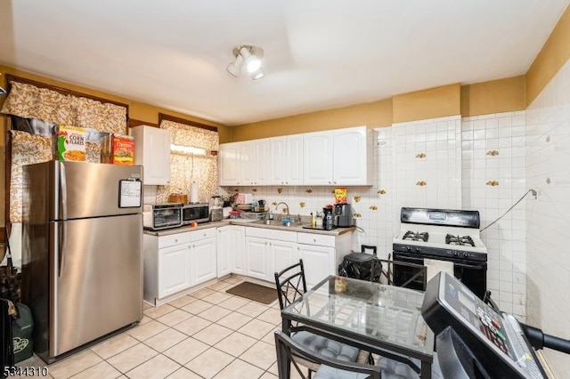 kitchen featuring white cabinets, stainless steel appliances, and a sink