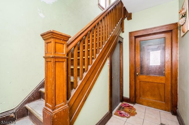 stairway featuring tile patterned flooring and baseboards