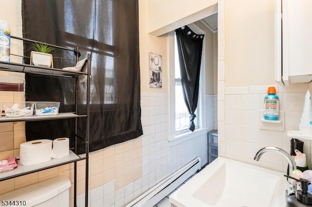 full bath with a sink, toilet, and tile walls