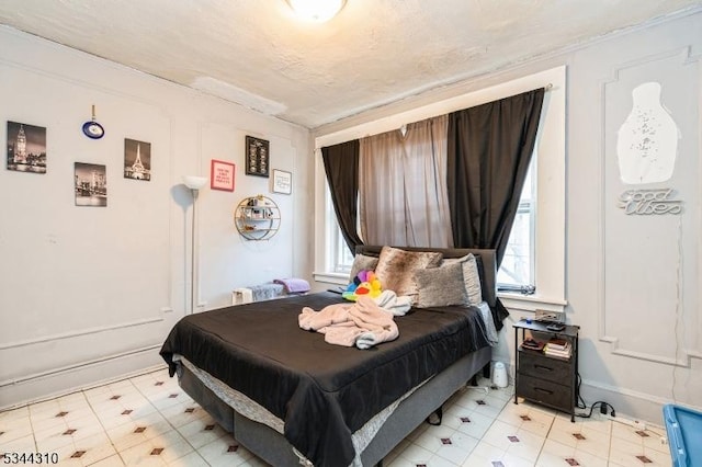 bedroom featuring light floors and baseboards