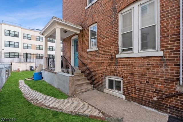 entrance to property with brick siding and fence