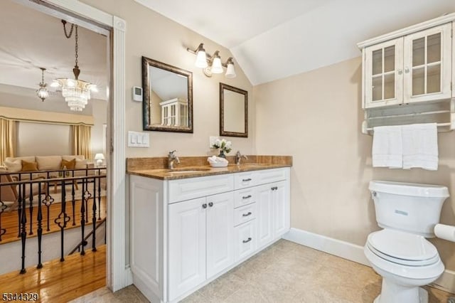 274 Ridgewood Ave, Glen Ridge Boro Twp, NJ 07028 - bathroom featuring double vanity, baseboards, lofted ceiling, a chandelier, and toilet
