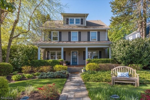 american foursquare style home with covered porch and a standing seam roof