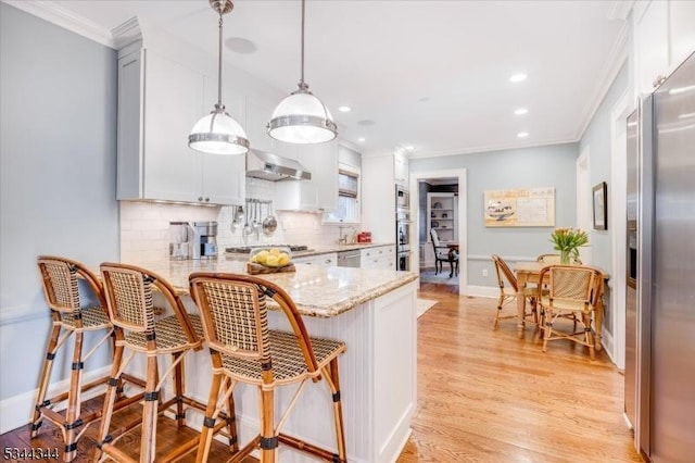 kitchen with crown molding, a peninsula, light stone countertops, backsplash, and hanging light fixtures