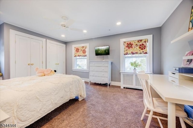 carpeted bedroom featuring multiple closets, baseboards, radiator heating unit, recessed lighting, and a ceiling fan