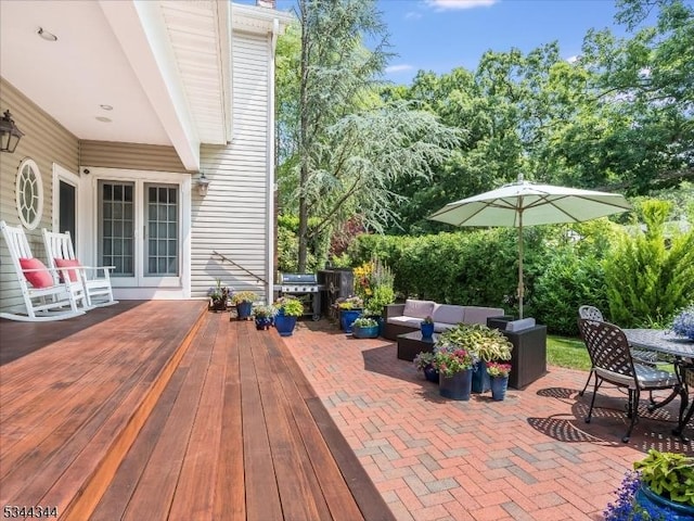 view of patio with a deck, an outdoor living space, outdoor dining area, and a grill