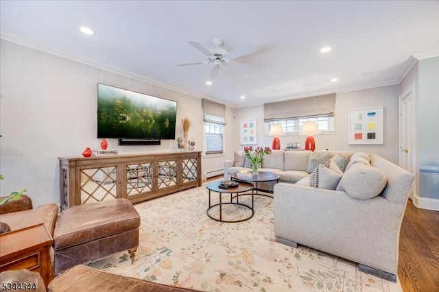 living area with ceiling fan, wood finished floors, a baseboard heating unit, ornamental molding, and recessed lighting
