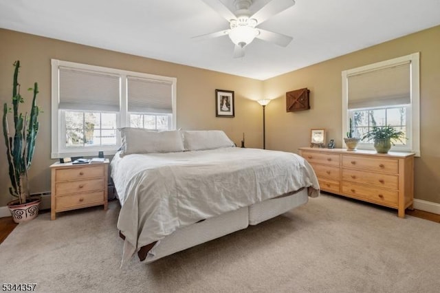 bedroom with baseboards, a ceiling fan, and light colored carpet