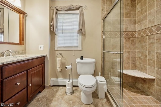 bathroom with a stall shower, vanity, baseboards, a baseboard heating unit, and toilet
