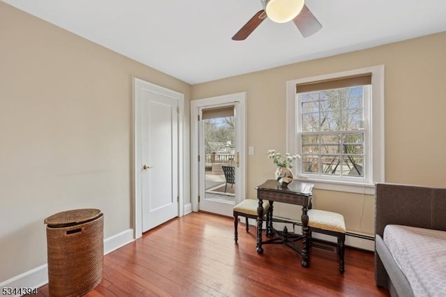 sitting room with wood finished floors, a ceiling fan, and baseboards