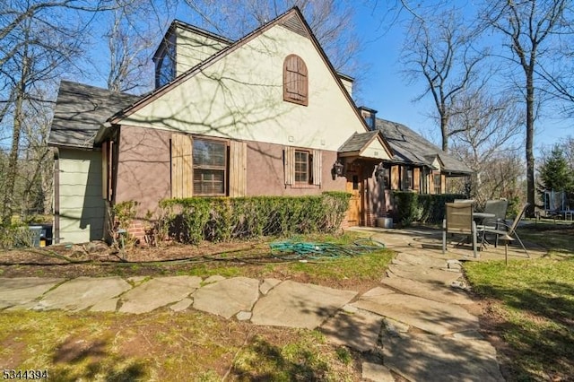 rear view of house with stucco siding and a patio