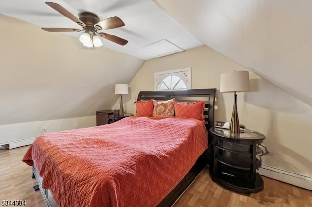 bedroom with baseboard heating, wood finished floors, vaulted ceiling, and a ceiling fan