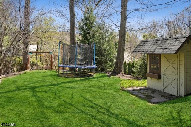 view of yard with a trampoline, an outbuilding, and a storage shed