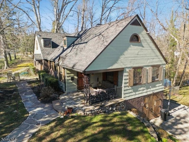 view of front of home with a patio area and a shingled roof