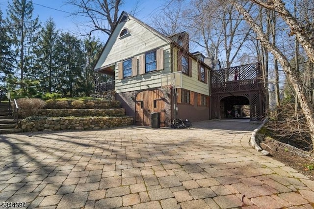 view of home's exterior featuring driveway and stairs