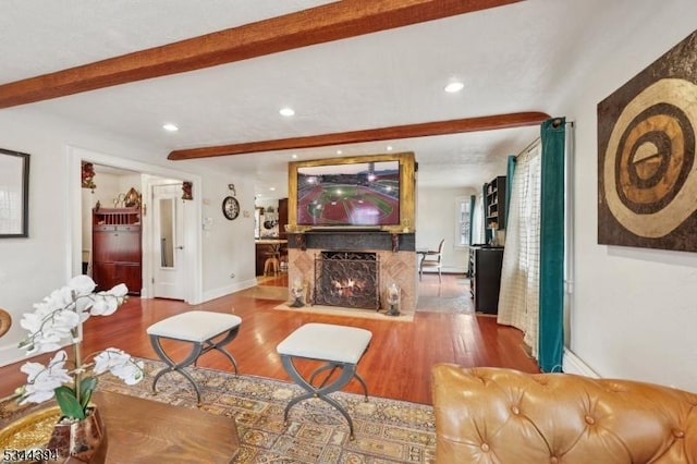 living room featuring beamed ceiling, baseboards, wood finished floors, and recessed lighting