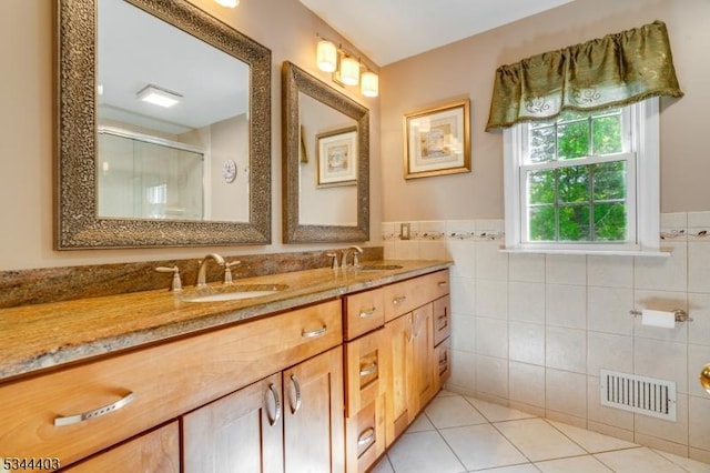 38 Beverly Dr, Hillsborough Twp, NJ 08844 - bathroom featuring tile patterned floors, tile walls, a shower stall, double vanity, and a wainscoted wall