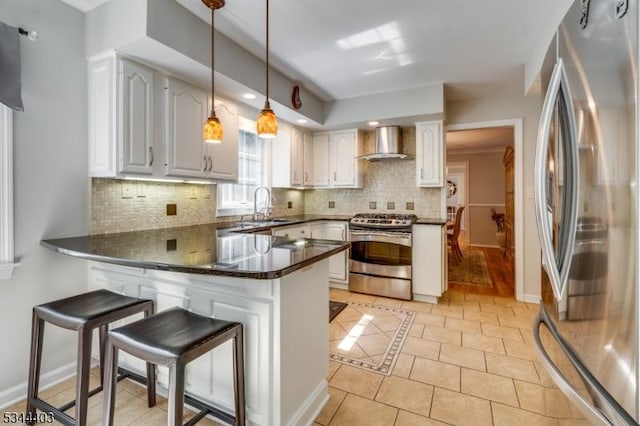 38 Beverly Dr, Hillsborough Twp, NJ 08844 - kitchen featuring stainless steel appliances, wall chimney exhaust hood, a peninsula, dark countertops, and light tile patterned floors