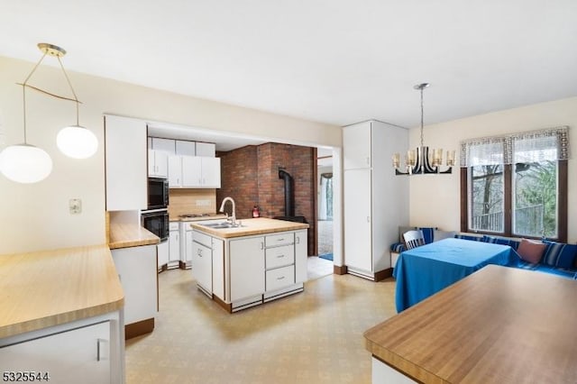 159 US Highway 206, Sandyston Twp, NJ 07826 - kitchen featuring white cabinets, decorative light fixtures, an island with sink, and a sink