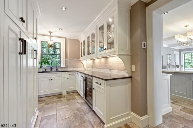 bar featuring decorative light fixtures, an inviting chandelier, tasteful backsplash, and wine cooler