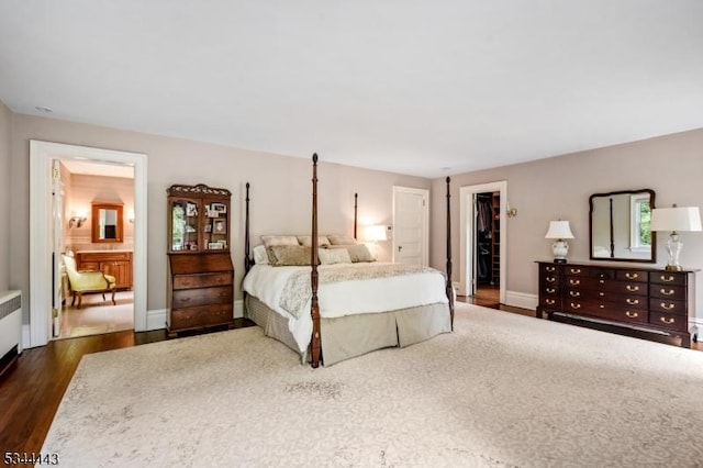 bedroom with a closet, dark wood-style flooring, and a spacious closet
