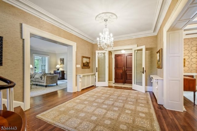 entryway featuring crown molding, baseboards, dark wood-style flooring, and a chandelier