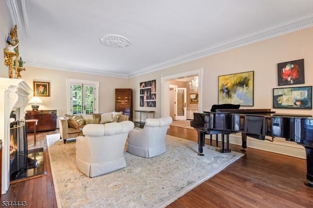 living area with a warm lit fireplace, ornamental molding, and wood finished floors
